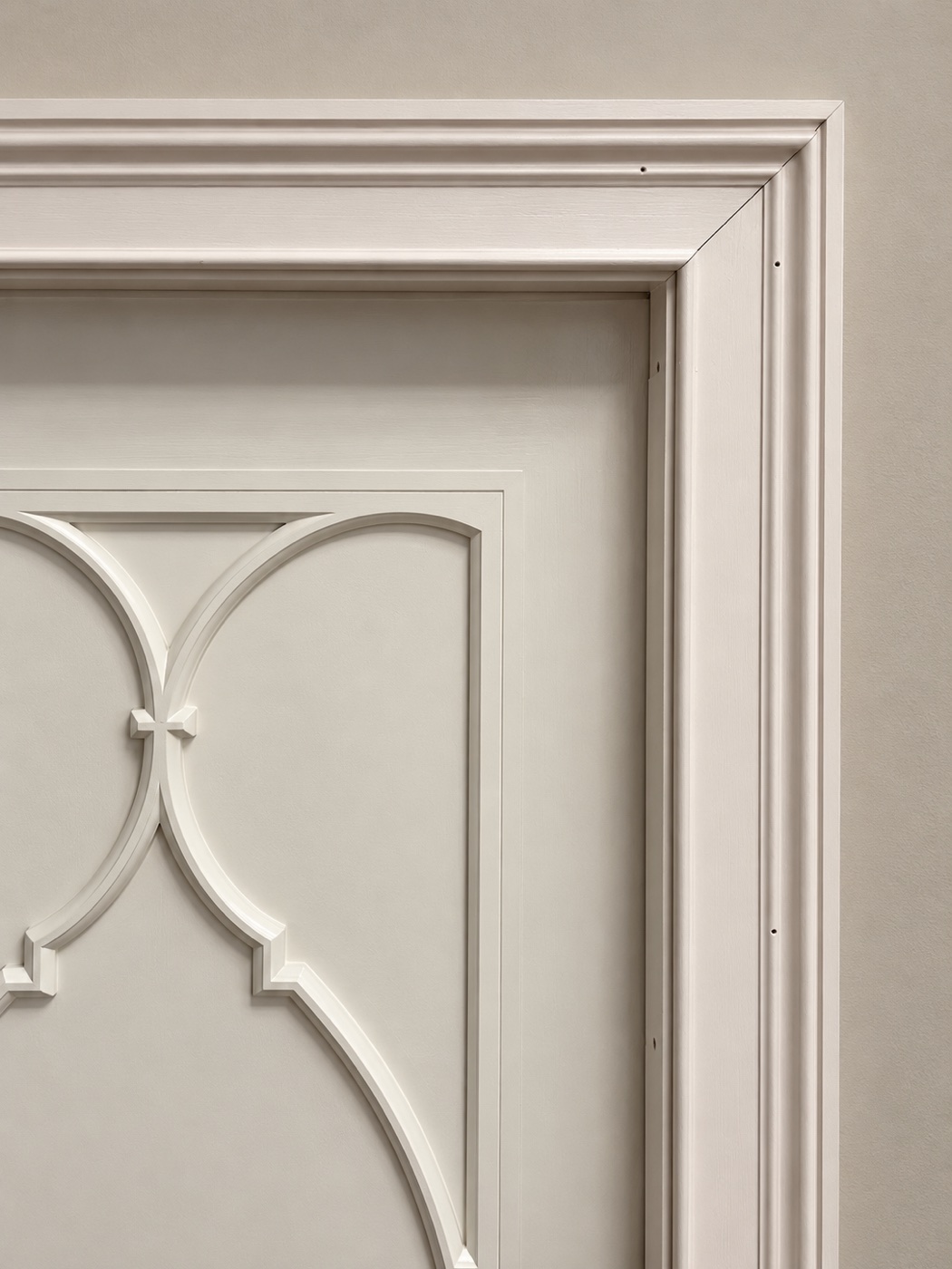 Sculpted white casing and the upper-right miter above a door with curved decorative moldings