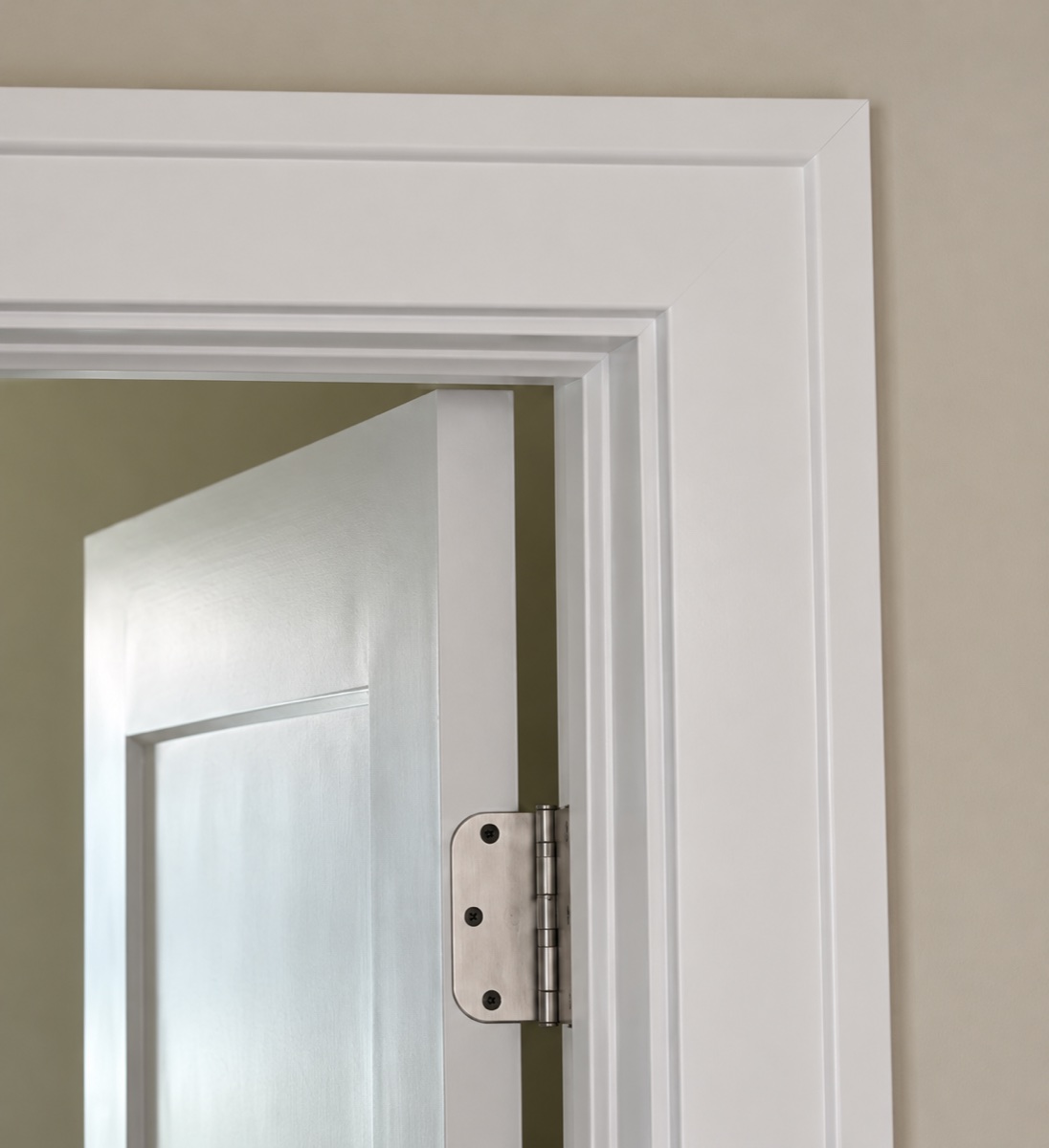 Close-up of the upper-right miter and stepped white casing around an interior door