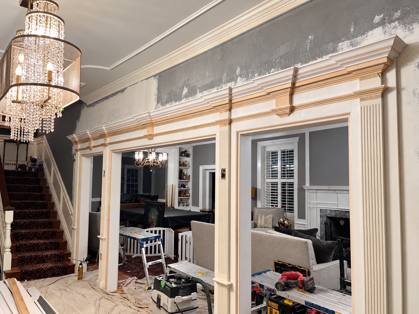 Historic opening with matched stacked molding profiles and fluted columns, showing natural wood and primed trim before paint
